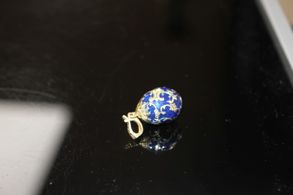 A modern 925 gilt white metal, blue enamel and diamond set egg shaped pendant, egg 20mm, gross weight 4.1 grams.